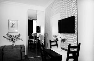 a living room with a television and a table with flowers at Residence Cavour 63 in Ravenna
