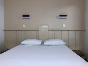 เตียงในห้องที่ HALT HOTEL - Choisissez l'Hôtellerie Indépendante