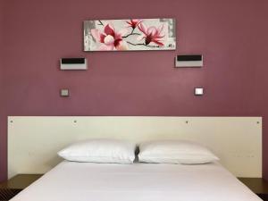 a bedroom with a white bed with a purple wall at HALT HOTEL - Choisissez l'Hôtellerie Indépendante in Lattes