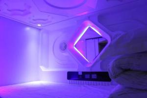 a room with a mirror and a purple light at Wuhan Worry-free Capsule Hotel in Wuhan