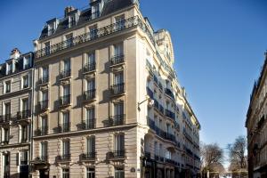 a large white building with balconies on a street at Hôtel Perreyve - Jardin du Luxembourg in Paris