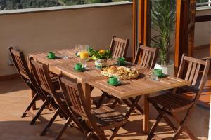 a wooden table with chairs and food and drinks on it at Villa Valeria in Positano