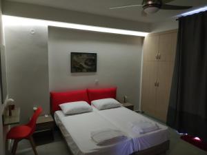 ハニア・タウンにあるThe 3 Brothers' Aptsのベッドルーム1室(赤いベッド1台、赤い椅子付)