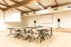 a conference room with tables and chairs and a whiteboard at Centre International de Séjour in Laval