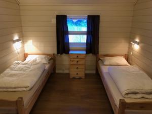 2 Betten in einem Zimmer mit Fenster in der Unterkunft Lofoten Feriesenter in Svolvær