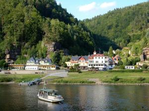 un barco en el agua frente a un pueblo en Pension Rauschenstein, en Bad Schandau
