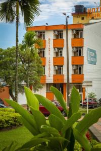 an apartment building with orange balconies and palm trees at Hotel Iguazu in Villavicencio