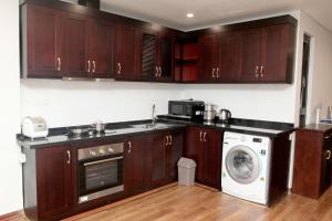 a kitchen with wooden cabinets and a washing machine at Monaco Building Double Queen Bedroom in Hanoi