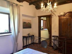 a bedroom with a bed and a chandelier at Haus Malerin mit Meerblick eingezäuntem Garten by ToscanaTour in Guardistallo