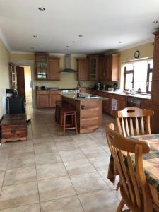 a large kitchen with wooden cabinets and a table and chairs at Beautiful Home on Lake Carrowmore in Belmullet