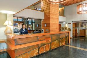 a woman standing behind a counter in a room at Hotel Frontera Plaza in Temuco