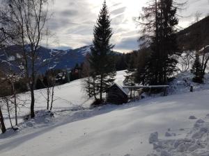 a snow covered slope with a cabin in the distance at Der Kristall by Globalimmoservice in Bad Kleinkirchheim