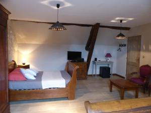 a bedroom with a bed and a desk and a tv at La sacristie in Nouâtre