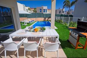 un patio con mesa, sillas y piscina en Villa Paradise, en Playa Paraiso