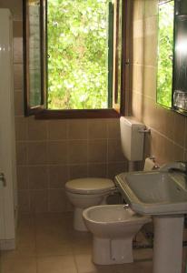een badkamer met een toilet, een wastafel en een raam bij Ca Ballarin in Rosolina