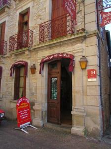 ヴィルフランシュ・ド・ルエルグにあるAuberge de la Posteの正面に看板とドアがある建物