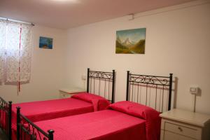 - 2 lits dans une chambre avec des draps rouges dans l'établissement Podere Marcigliano, à Cortone