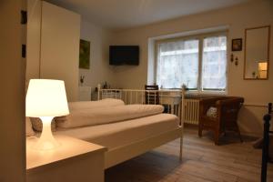 a bedroom with a bed with a lamp and a window at Kiki's B&B in Basel