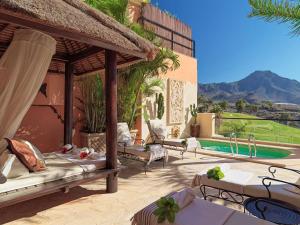 a resort patio with beds and a swimming pool at Royal Garden Villas, Luxury Hotel in Adeje