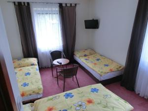 a room with two beds and a table and chairs at Vila Evička in Sobotka