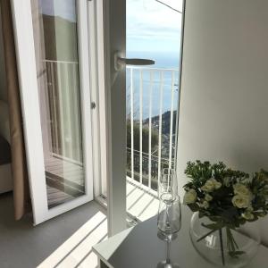 - une table avec un vase de fleurs sur le balcon dans l'établissement GiorGiada Luxury, à Castelmola