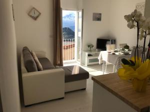 a living room with a couch and a view of a balcony at GiorGiada Luxury in Castelmola