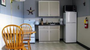 
a kitchen with a refrigerator and a table at Mountain View Motel & Cottages in Pleasant Bay
