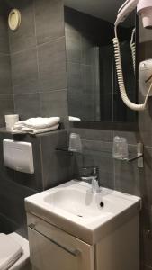 a bathroom with a white sink and a mirror at Hôtel du Maine in Paris