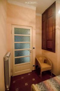 een slaapkamer met een deur, een stoel en een raam bij Bussana Forever, Sanremo Est in Sanremo