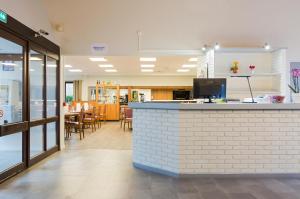 a restaurant with a counter and a dining room at Comfort Hotel Etampes in Étampes