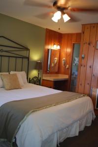 a bedroom with a large bed and a ceiling fan at Trees Motel in Bishop