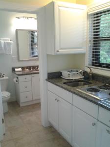 a white kitchen with a sink and a toilet at Surf & Sand Beach Motel in South Yarmouth