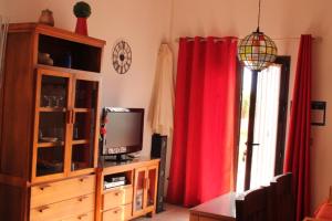 a living room with red curtains and a television at Villa El Nido in Nerja