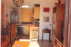 a kitchen with a refrigerator and a table in it at Villa El Nido in Nerja