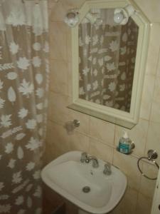 Un baño con lavabo y cortina de ducha. en Playa Shaw 497, en Pinamar