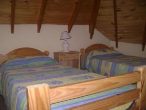 2 camas en un dormitorio con techos de madera en Playa Shaw 497, en Pinamar