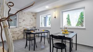 - une cuisine avec des tables et des chaises noires dans la chambre dans l'établissement B&B Villa Vela, à Umag