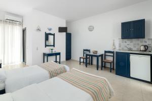 een hotelkamer met 2 bedden en een keuken bij Kozas Superior Apartments in Archangelos