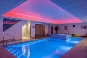 a swimming pool with purple lights in a building at Orsett Hall in Orsett