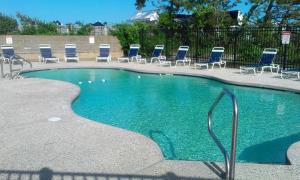 a swimming pool with chairs and a bunch of chairs at Surf & Sand Beach Motel in South Yarmouth