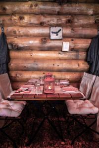 una mesa en una habitación con una pared de madera en Hôtel Le Relais Alpin, en Les Mosses