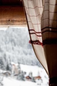 a window with a view of a snow covered mountain at Hôtel Le Relais Alpin in Les Mosses