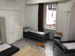 Cette chambre comprend 2 lits, une table et une fenêtre. dans l'établissement Unterkunft Göppingen, à Göppingen