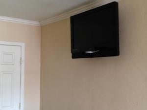 a flat screen tv hanging on a wall at Value Inn in Sylmar