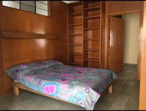 a bed in a room with wooden shelves at Casa Alsacia in Guadalajara