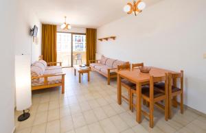 a living room with a table and a couch at Apartamentos Jovial in San Antonio