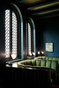a waiting room with green chairs and two windows at Palihouse Santa Monica in Los Angeles