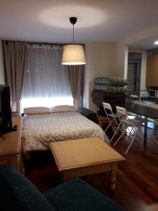 a bedroom with a bed and a living room with a table at Apartamento en c/ Peroneros in Latas