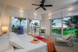 a bedroom with a bed and a large window at Tanusas Retreat & SPA in Puerto Cayo