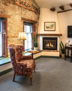 a living room with a chair and a fireplace at Washington House Inn in Cedarburg